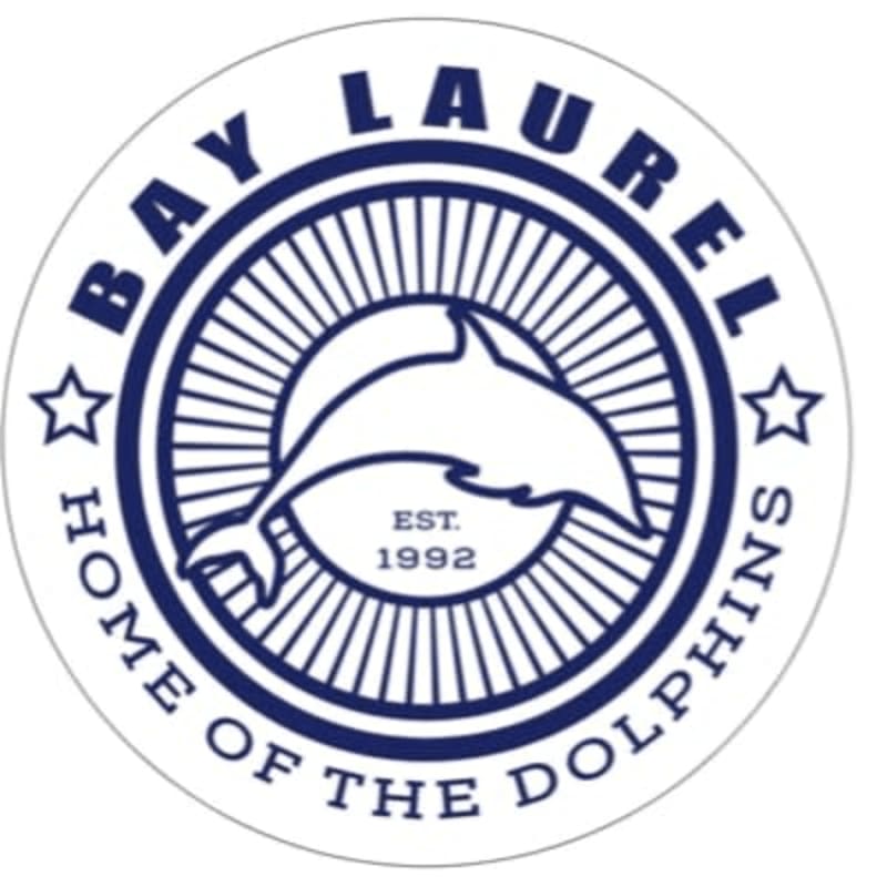 A white dolphin leaps within a circular emblem featuring radiating lines and the text "BAY LAUREL HOME OF THE DOLPHINS EST. 1992" in dark blue.