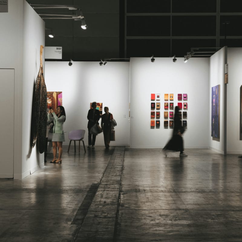 People browse art in a brightly lit gallery.
