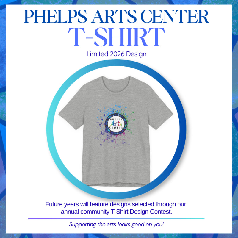 A grey t-shirt with a colorful splatter design and "Phelps Arts Center" logo is displayed within a blue and white circular frame, set against a textured blue background.