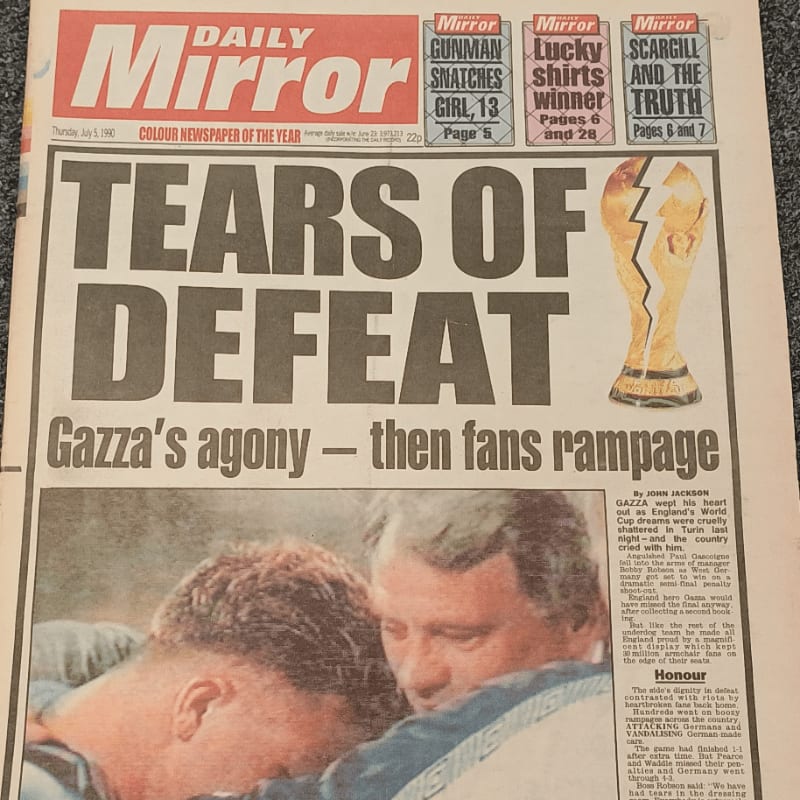 A newspaper headline reads "TEARS OF DEFEAT" with a picture of two men embracing in the foreground and a broken trophy in the background.