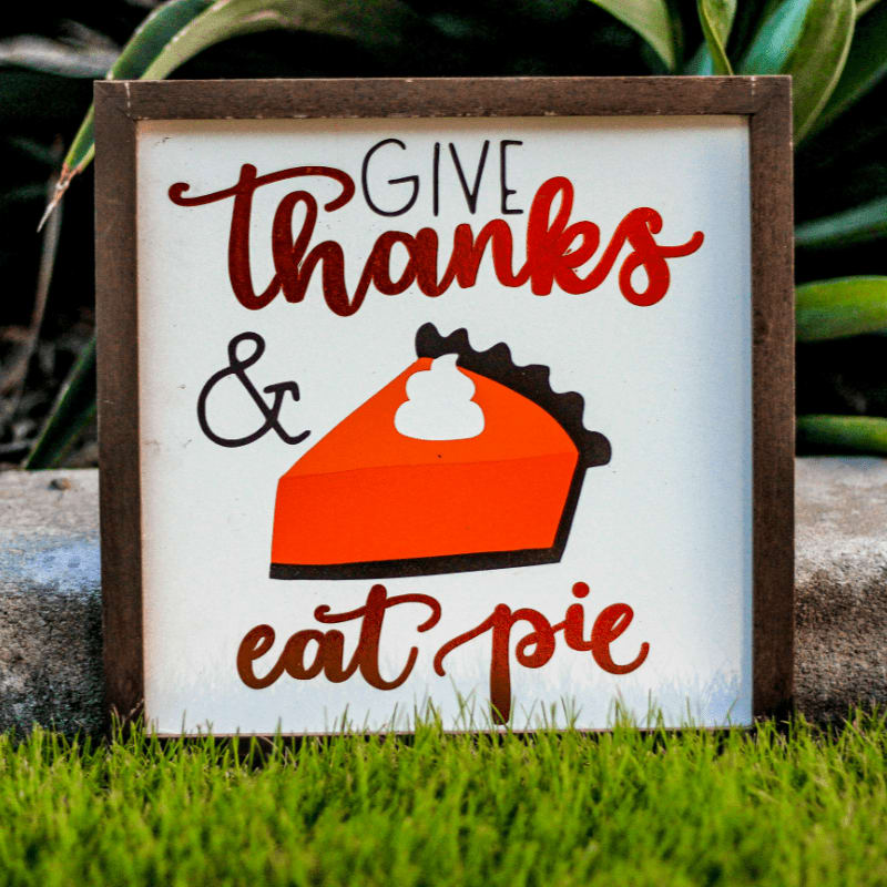 Give Thanks and Eat Pie poster with brown frame on green grass field