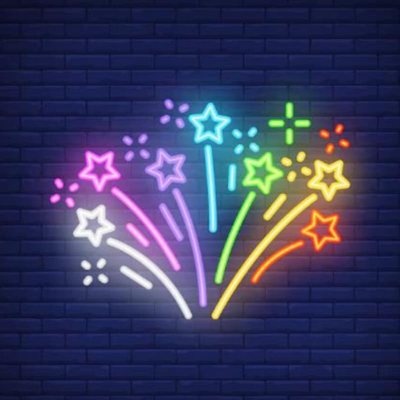 A vibrant neon firework display of stars and sparks illuminates a dark brick wall.