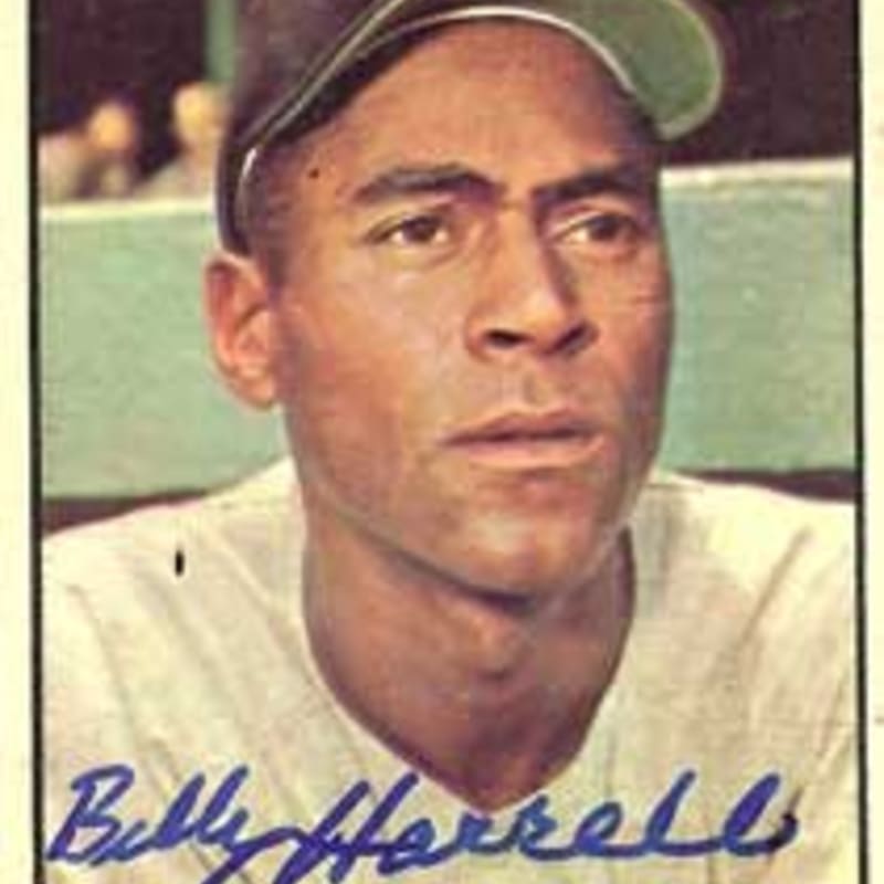 A close-up of a baseball player's face in the foreground is set against a blurred background of what appears to be a stadium crowd.