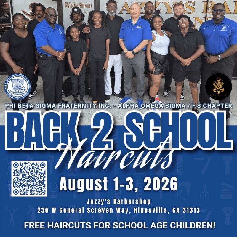 A group of people, some wearing blue shirts, stand in front of a barbershop with a "Back 2 School Haircuts" advertisement.