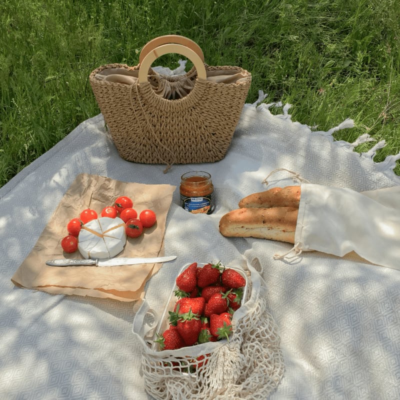 a picnic table with strawberries and bread
