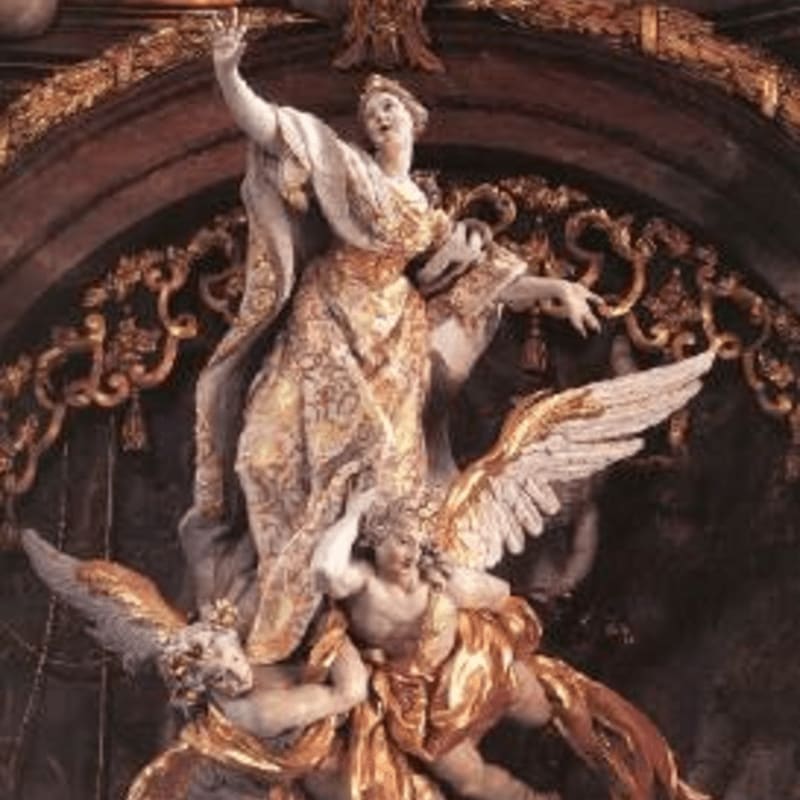 A gilded sculpture of a woman with outstretched arms stands above two winged cherubs, set against an ornate, dark background.