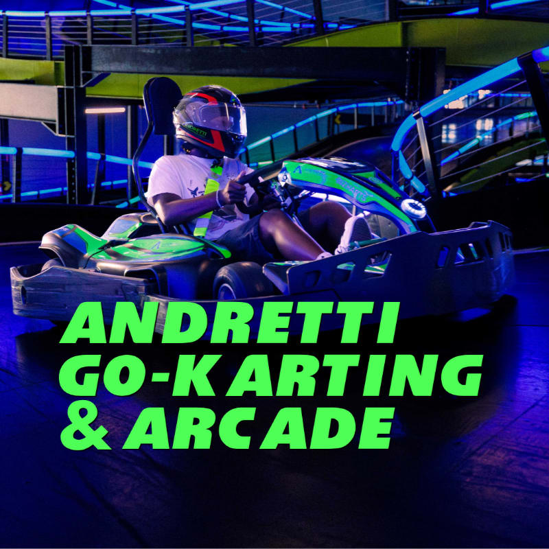 A person in a helmet races a green go-kart on a track with neon lights and "ANDRETTI GO-KARTING & ARCADE" text in the foreground.