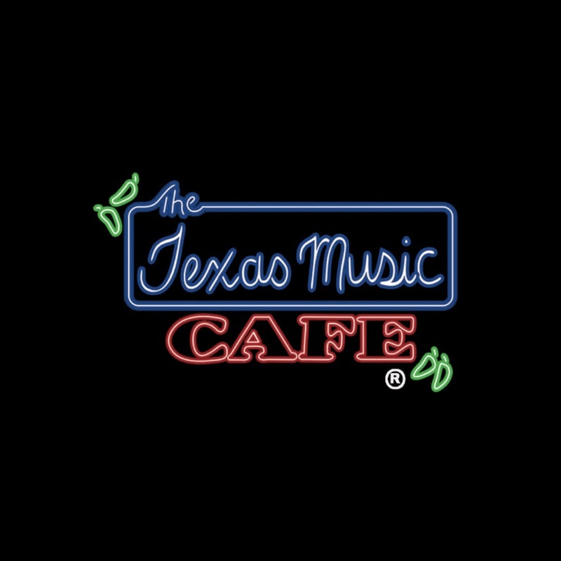 Neon lights spell out "The Texas Music CAFE" in blue and red against a black background, with green chili pepper accents on either side.