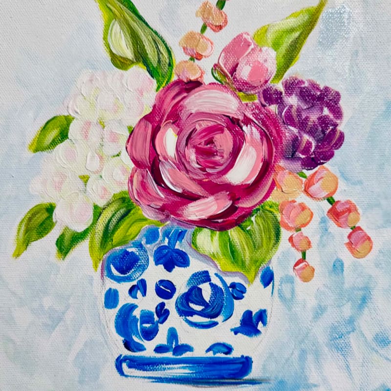 A vibrant bouquet of pink, white, and purple flowers spills from a blue and white patterned vase against a soft blue background.