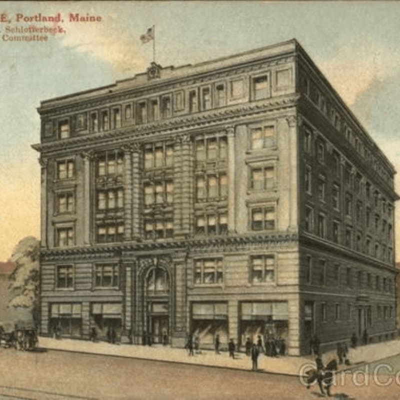 A grand, multi-story building with an ornate facade stands on a street with horse-drawn carriages and pedestrians in the foreground, against a muted, hazy sky in the background.