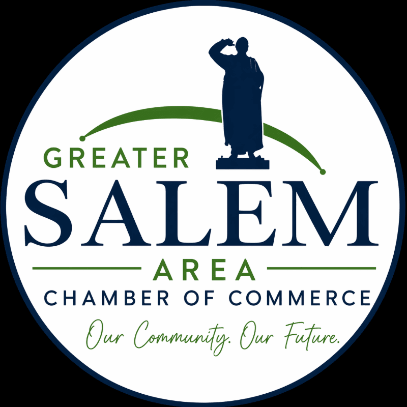 A dark blue silhouette of a person saluting stands atop a pedestal in the foreground, set against a white circular background with green and dark blue text that reads "GREATER SALEM AREA CHAMBER OF COMMERCE" and "Our Community. Our Future."