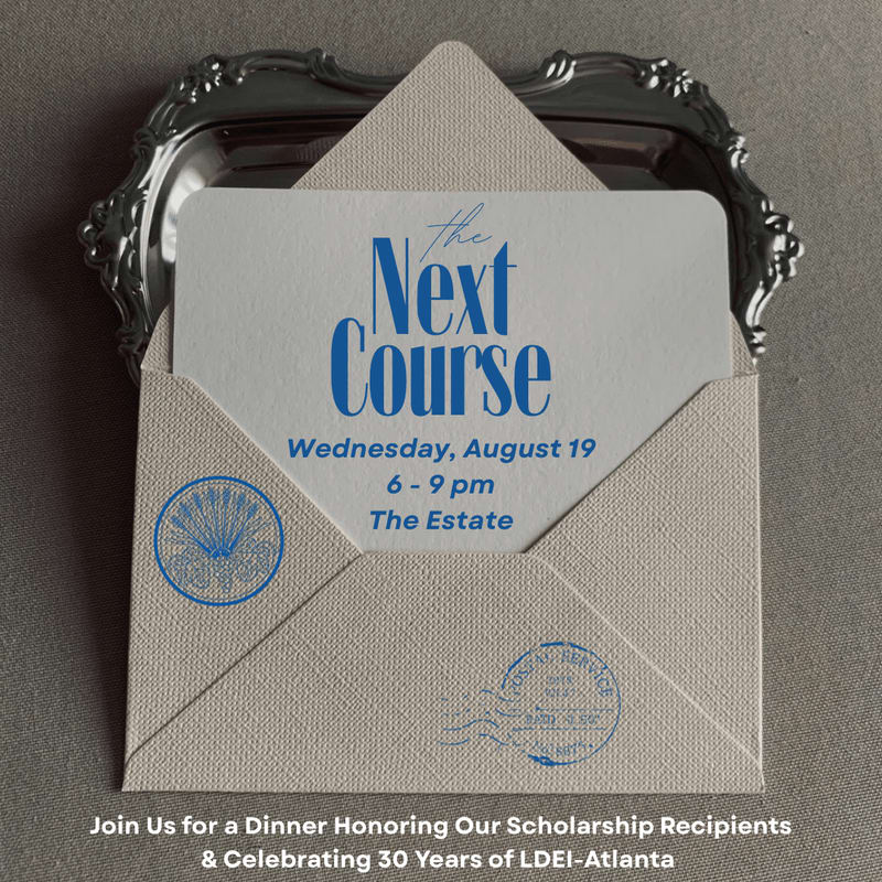 A cream-colored envelope with a card inside reading "The Next Course" is placed on a silver tray against a gray background.