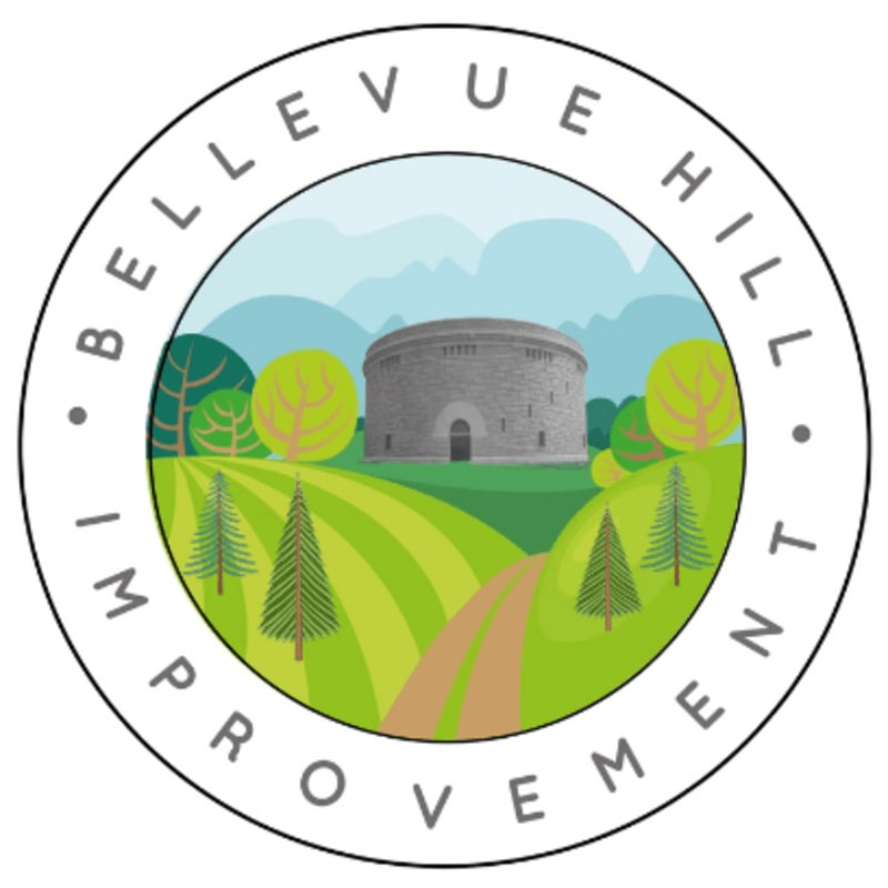 A circular emblem frames a stylized landscape with a stone building and rolling green hills in the background, and a dirt path winding through evergreen trees in the foreground.