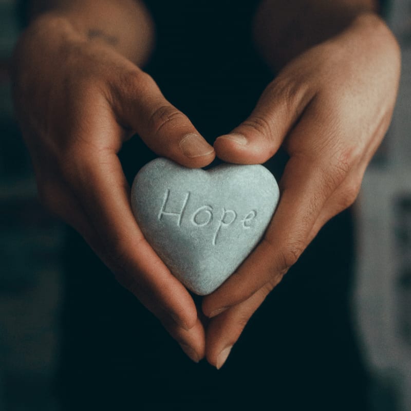 person holding gray heart shape ornament