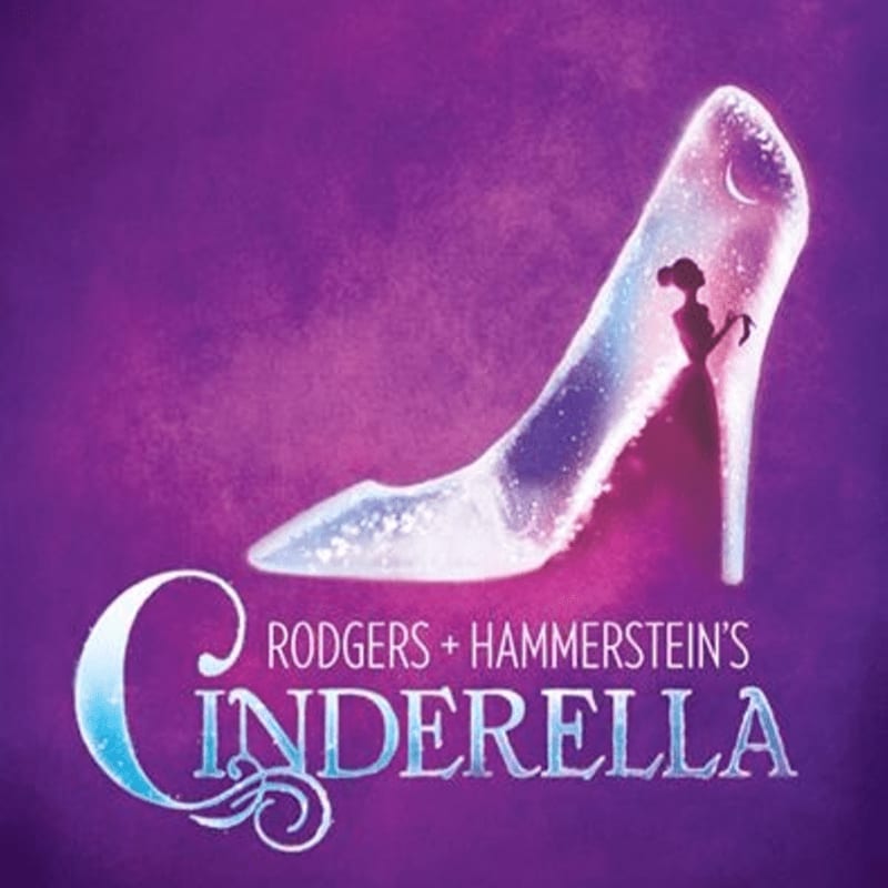 A sparkling glass slipper with a silhouette of Cinderella inside rests on a purple, misty background with the title "Rodgers + Hammerstein's Cinderella" in stylized lettering.