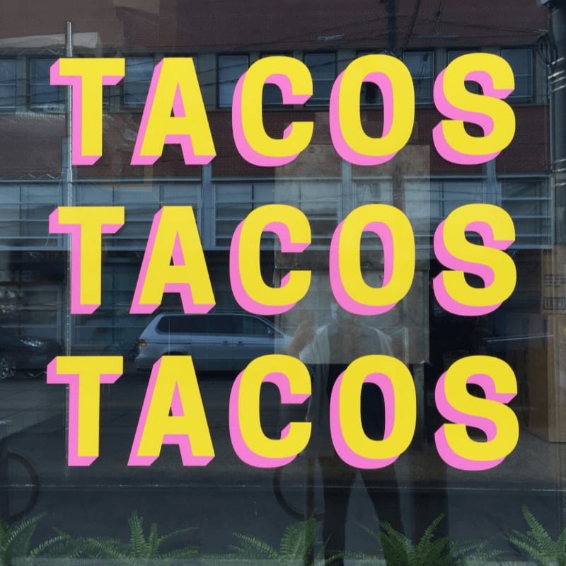 a window with a sign that says tacos tacos