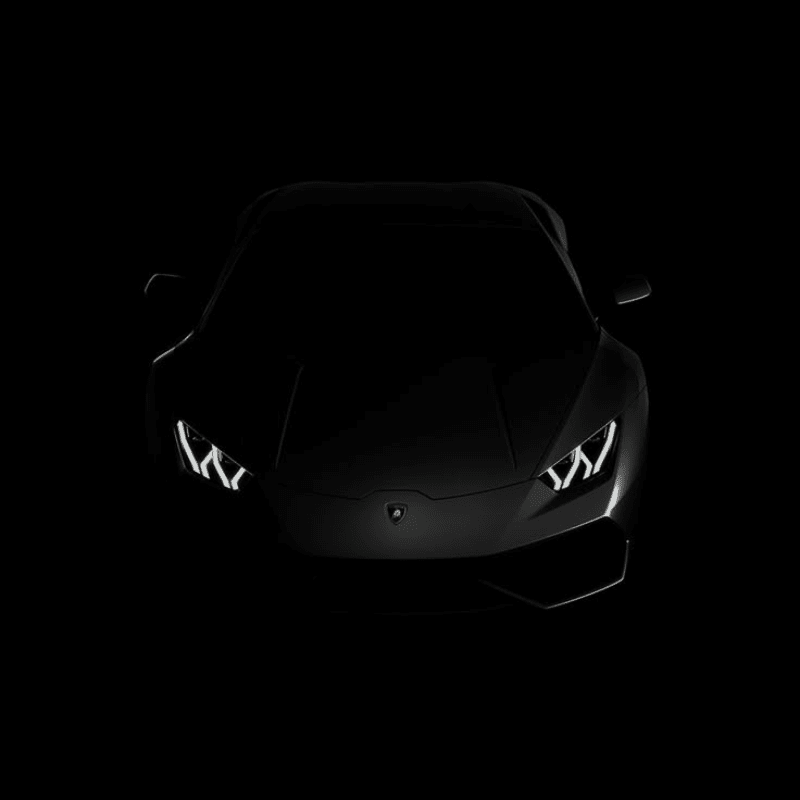 A dark, matte black sports car with illuminated headlights is set against a completely black background.