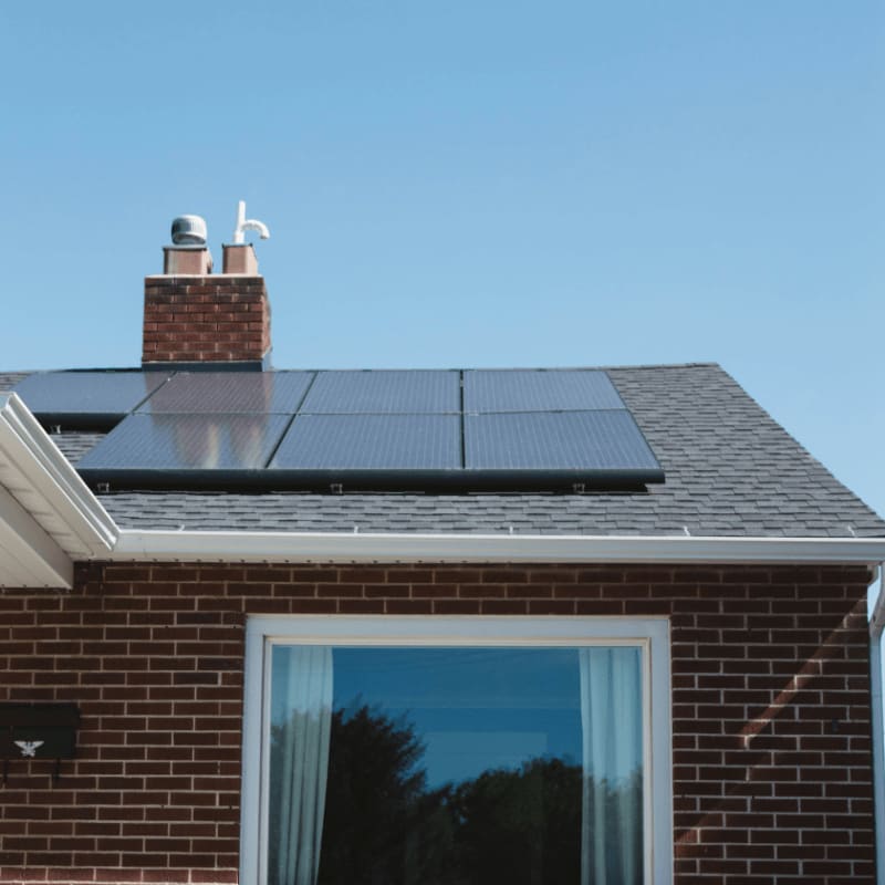 brown brick house with solar panels on roof