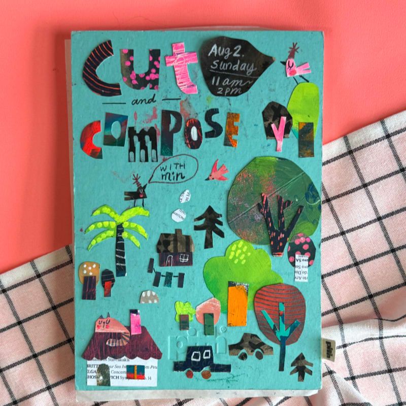 A turquoise collage of cut-out shapes depicting a whimsical outdoor scene with houses, trees, and animals is laid on a pink and white checkered cloth.