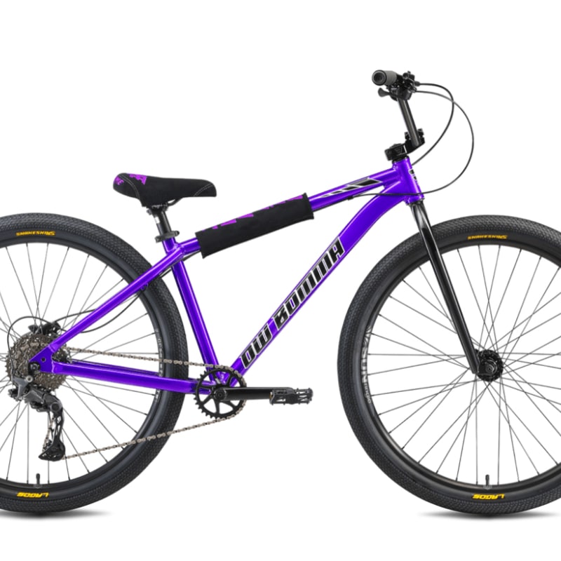 A vibrant purple BMX bike with black tires and accents sits against a plain white background.