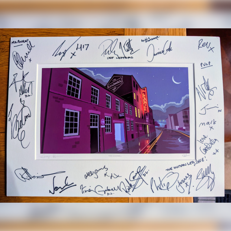 A framed print of a cartoonish, rain-slicked street scene with a building labeled "Academy" is surrounded by numerous handwritten signatures.