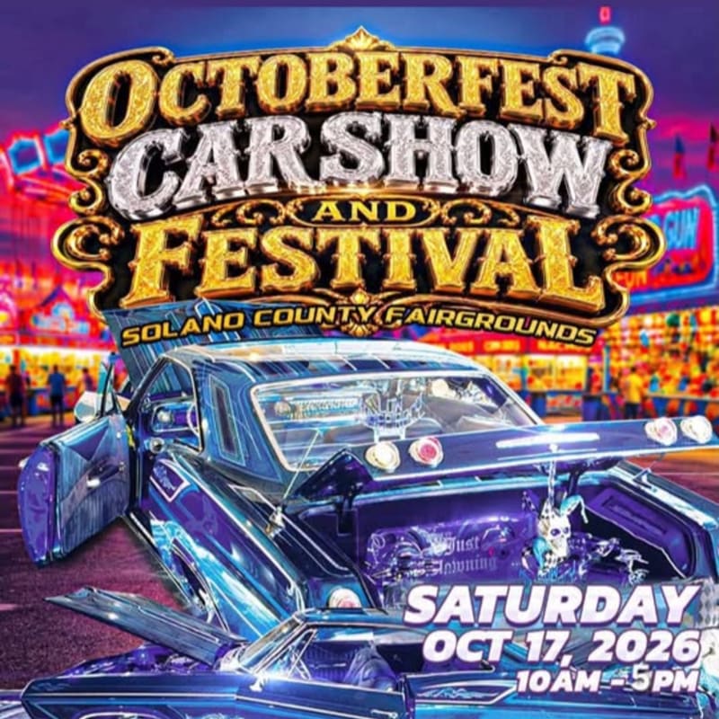 A gleaming purple lowrider with its doors open is showcased in the foreground against a vibrant, illuminated background of a fairground at the Octoberfest Car Show and Festival.