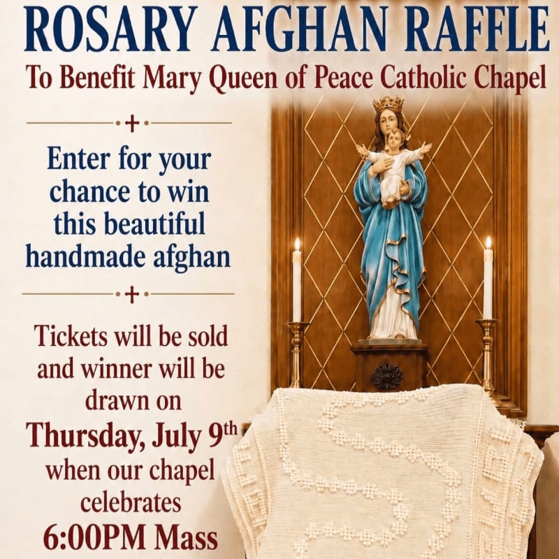 A raffle announcement for a handmade afghan is displayed in front of a statue of Mary and Jesus, with candles flanking the statue and a portion of the afghan visible in the foreground.