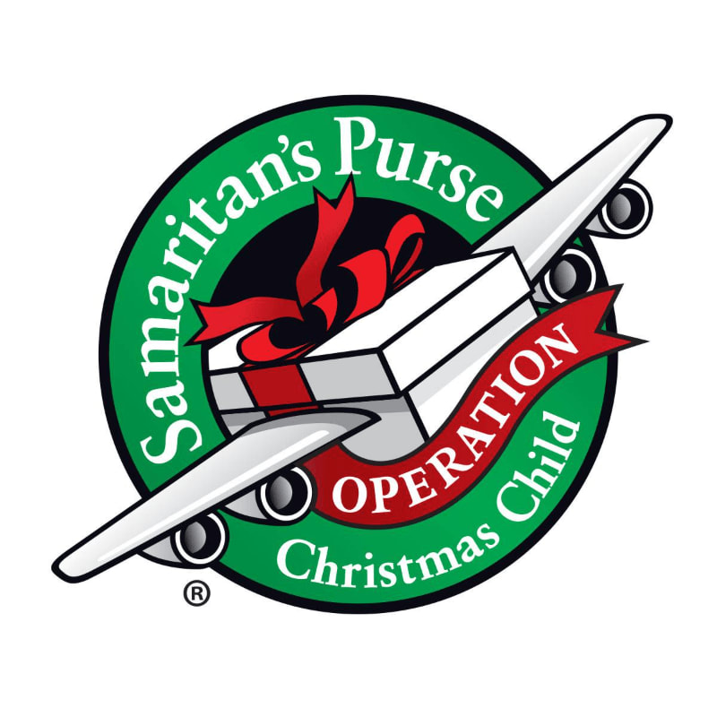 A white airplane with a gift box on its wings, adorned with a red ribbon, flies across a green circle with the text "Samaritan's Purse Operation Christmas Child" in white and red lettering.