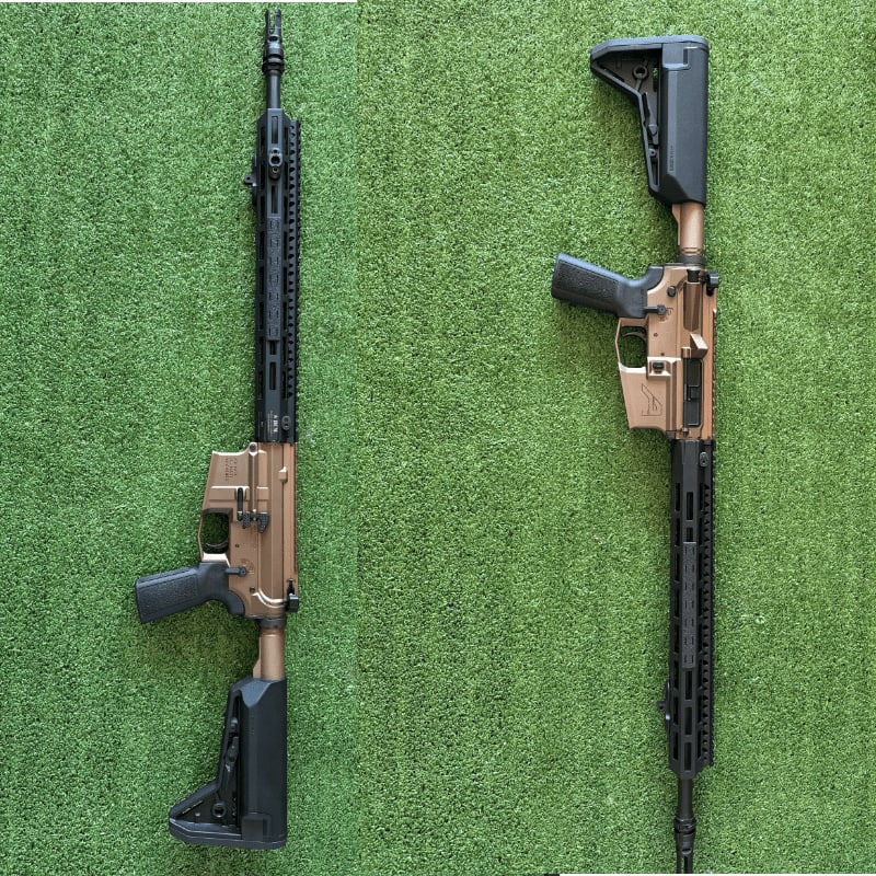 Two tan and black rifles lie on a green, artificial turf background.