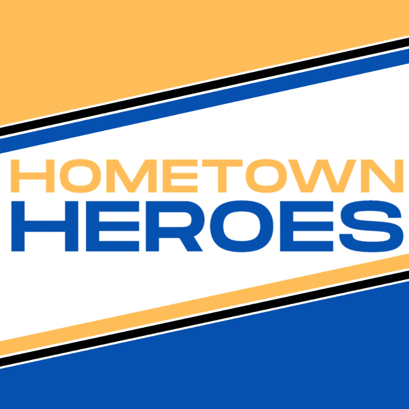 The words "HOMETOWN HEROES" are displayed in large, bold letters against a white background, framed by diagonal bands of orange and blue in the background.