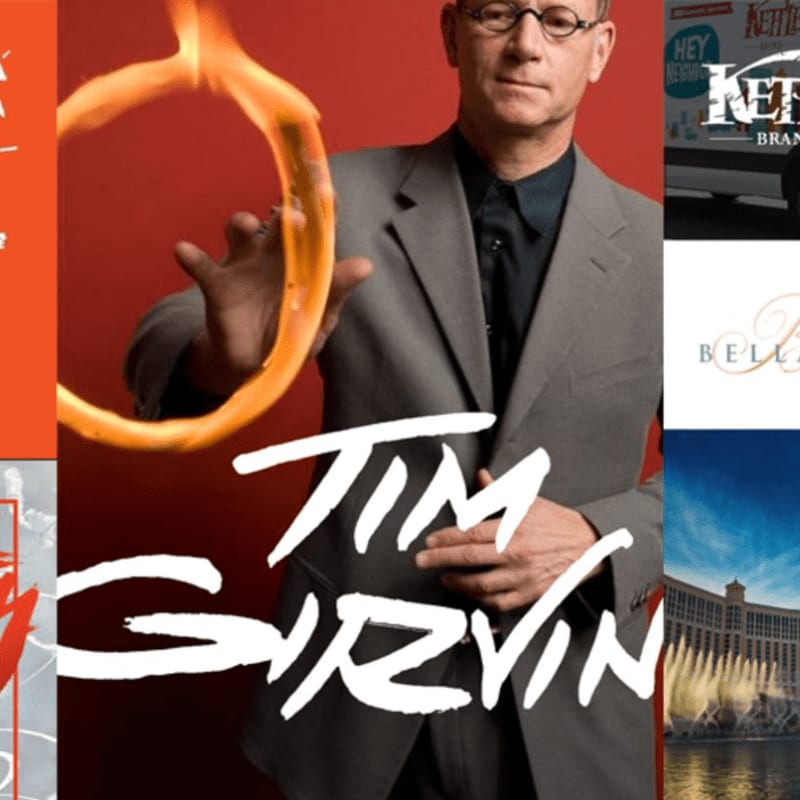 A man in a suit holds a flaming ring in the foreground, with a collage of various images including a van, a hotel, and a movie poster in the background.