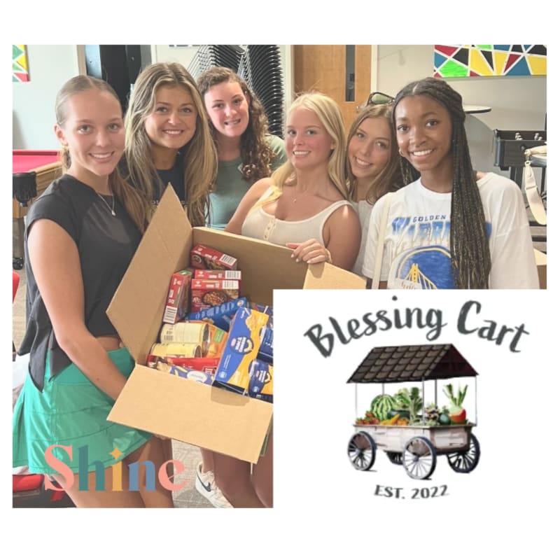 Six smiling young women hold a box of food in front of a colorful background with a "Blessing Cart" logo.