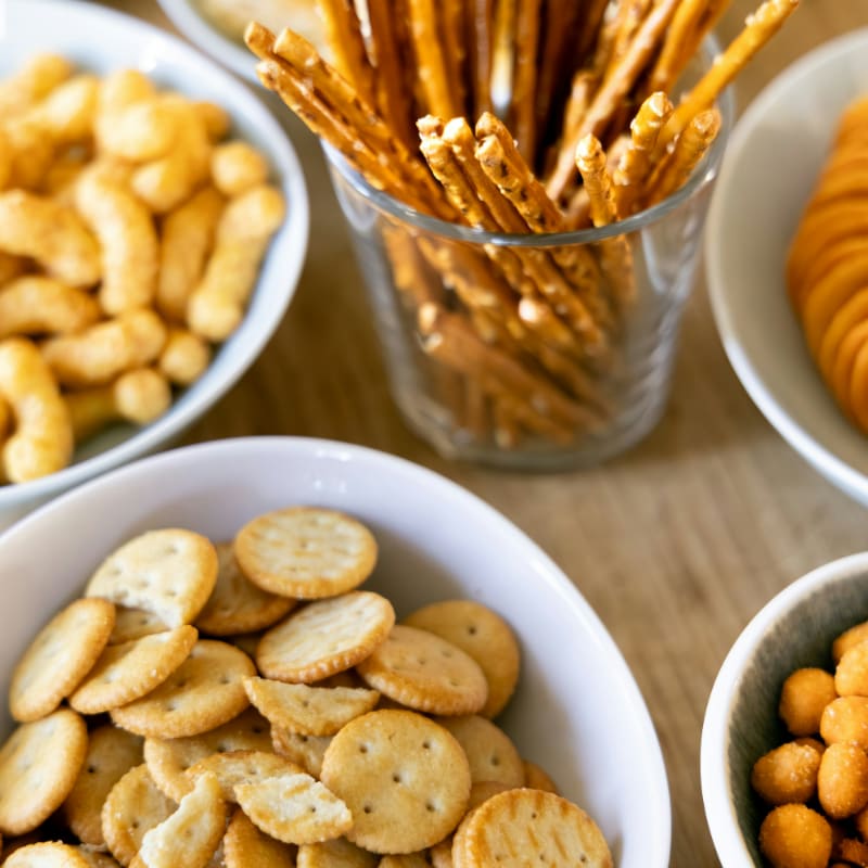 a wooden table topped with bowls of crackers
