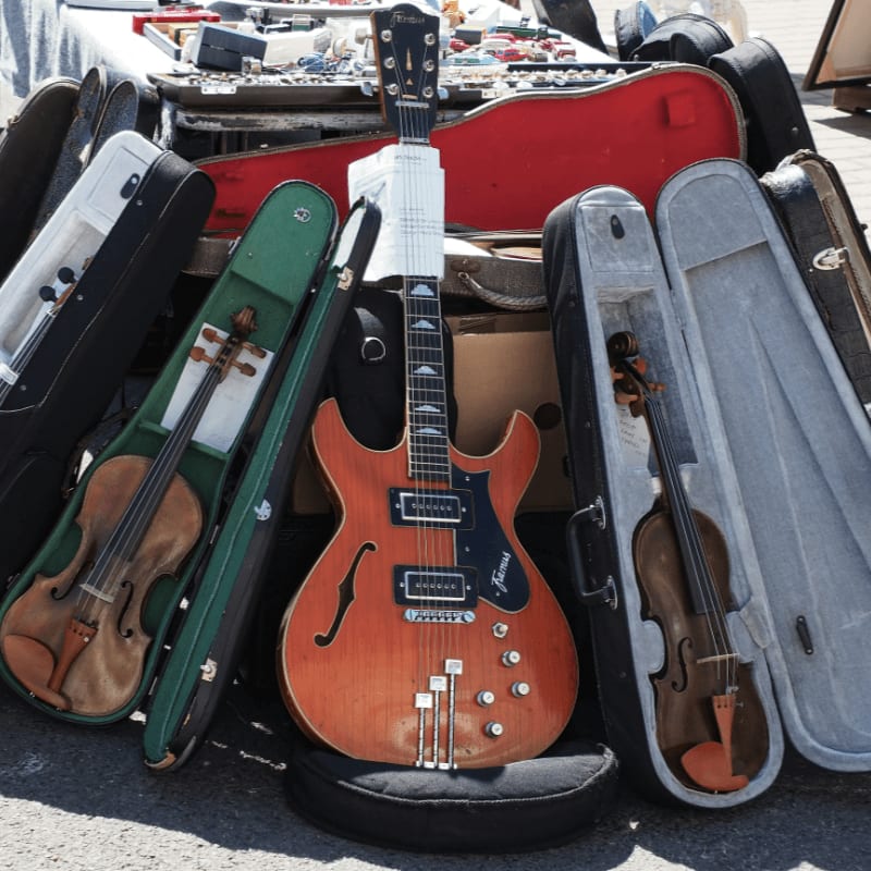 a group of guitars and cases sitting on the ground