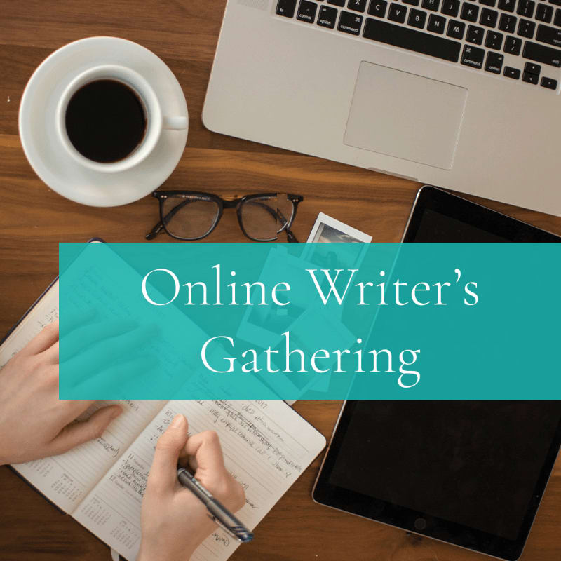 A person's hands write in a notebook in the foreground, while a laptop, tablet, coffee cup, and glasses rest on a wooden desk in the background.