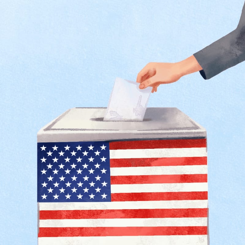 A hand drops a ballot into a US flag-decorated ballot box against a light blue background.