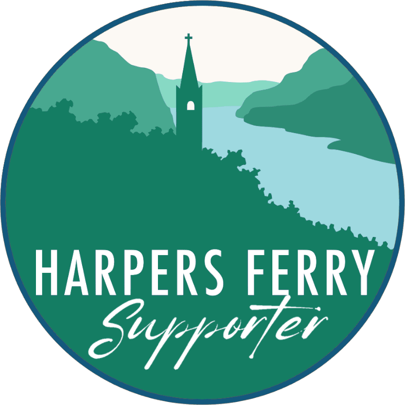 A church steeple rises from a green hillside in the foreground, overlooking a light blue river and distant mountains in the background, all within a circular emblem that reads "HARPERS FERRY Supporter."