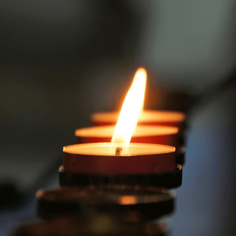 lighted candle in brown metal candle holder