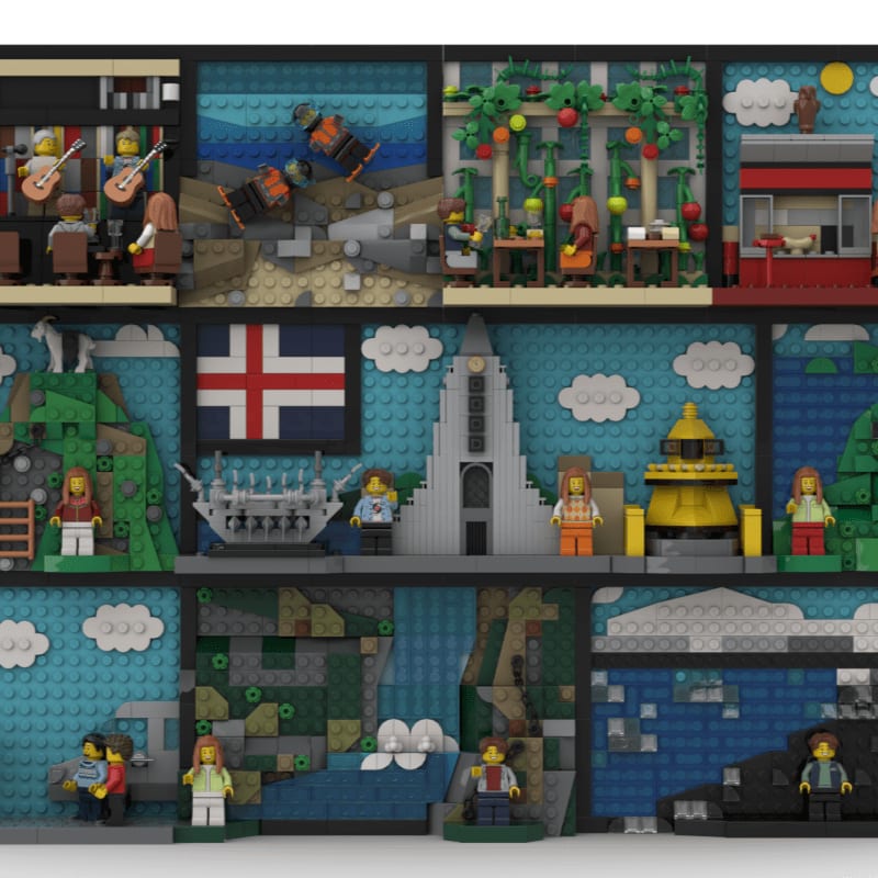 A Lego diorama displays various scenes, from a band playing in a cafe to a lighthouse and a waterfall, all set against a backdrop of blue skies and clouds.