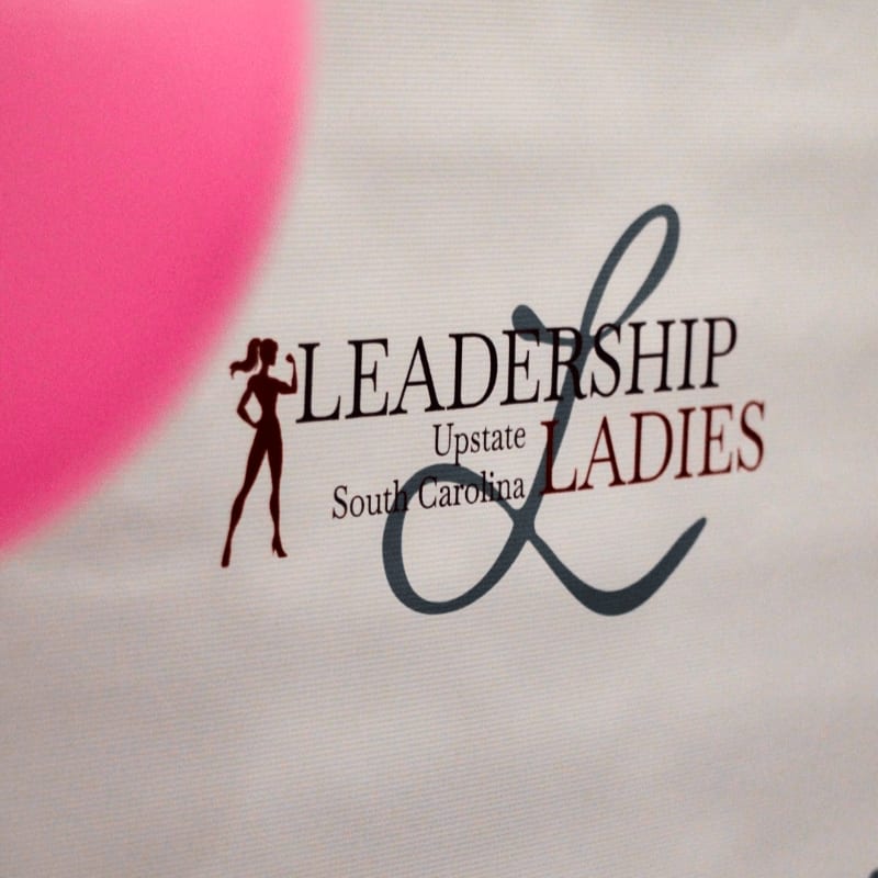 A large pink balloon is in the foreground, with a banner in the background displaying the "Leadership Upstate South Carolina Ladies" logo.