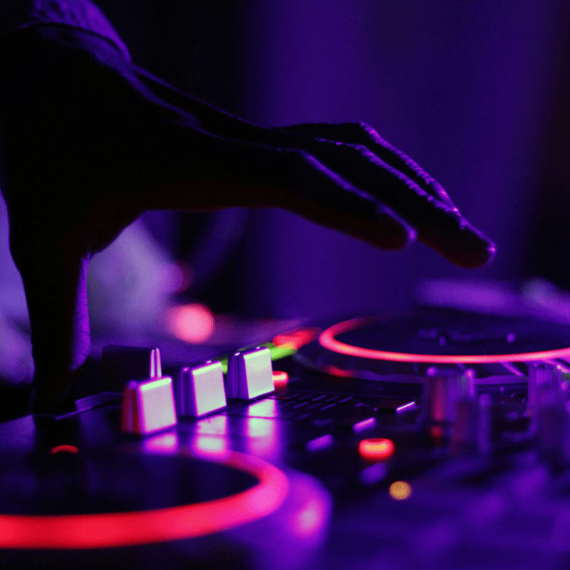 selective focus silhouette photography of man playing red-lighted DJ terminal