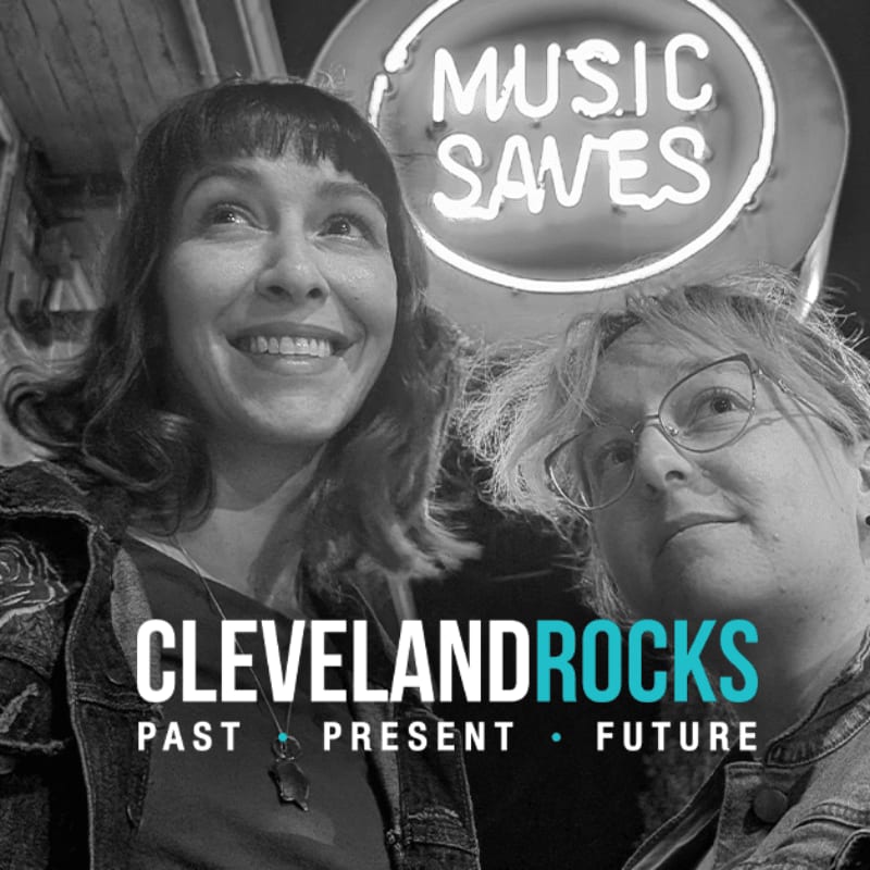 Two women smile under a "MUSIC SAVES" neon sign with "CLEVELAND ROCKS PAST PRESENT FUTURE" text overlay.