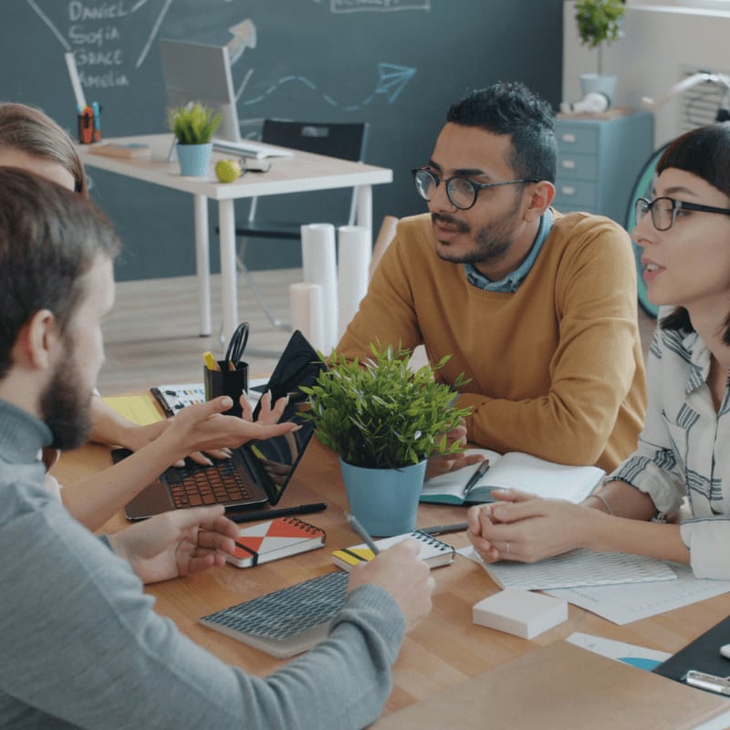 Diverse team collaborating around a table in office.
