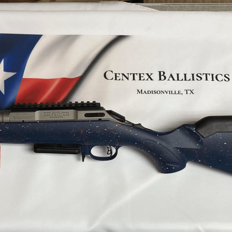 A speckled blue rifle rests on a white cloth with a Texas flag and "Centex Ballistics" logo in the background.
