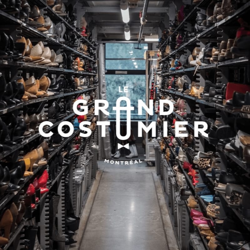 Rows of shoes fill shelves in a storage room, with the text "LE GRAND COSTUMIER MONTREAL" visible in the background.