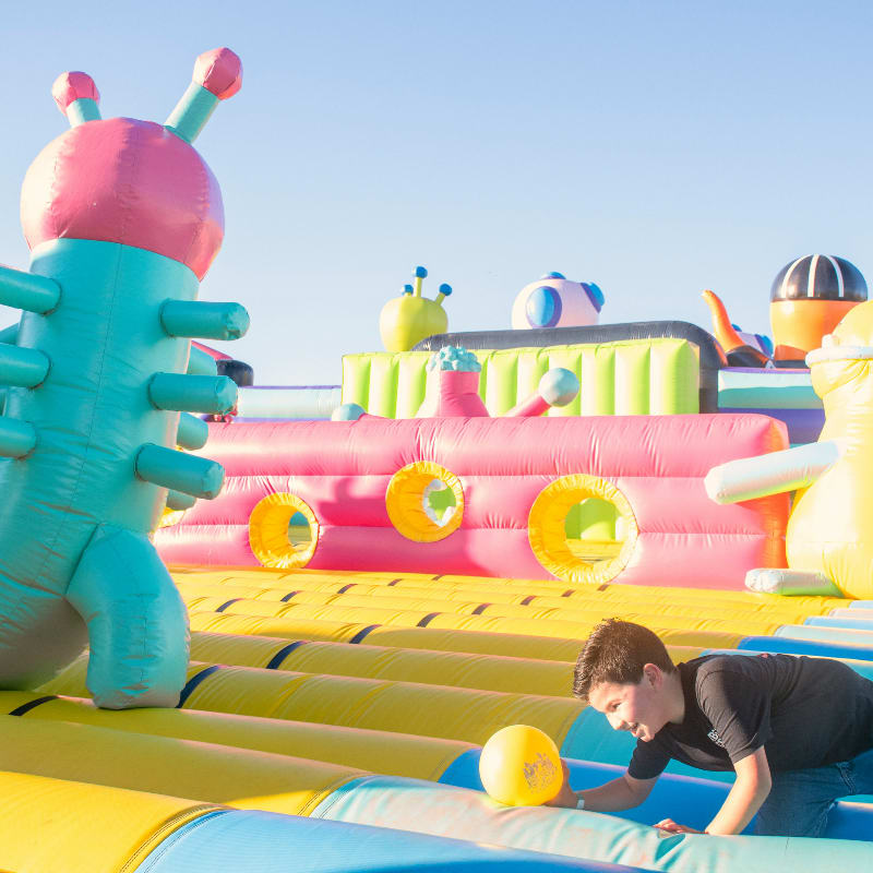 a woman is playing in an inflatable park