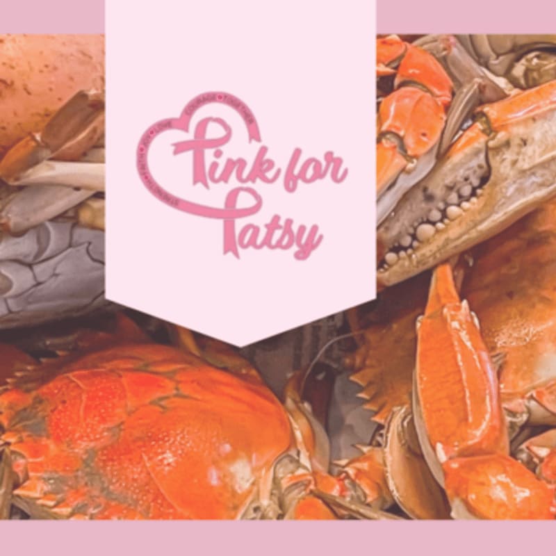 Cooked crabs fill the foreground, with a pink banner featuring a breast cancer ribbon and the words "Pink for Patsy" overlaid on the background.
