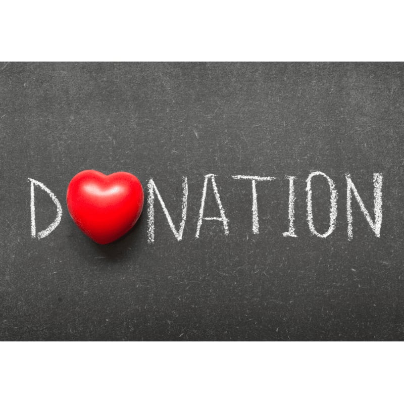 A red heart replaces the "O" in the word "DONATION" written in chalk on a dark chalkboard.