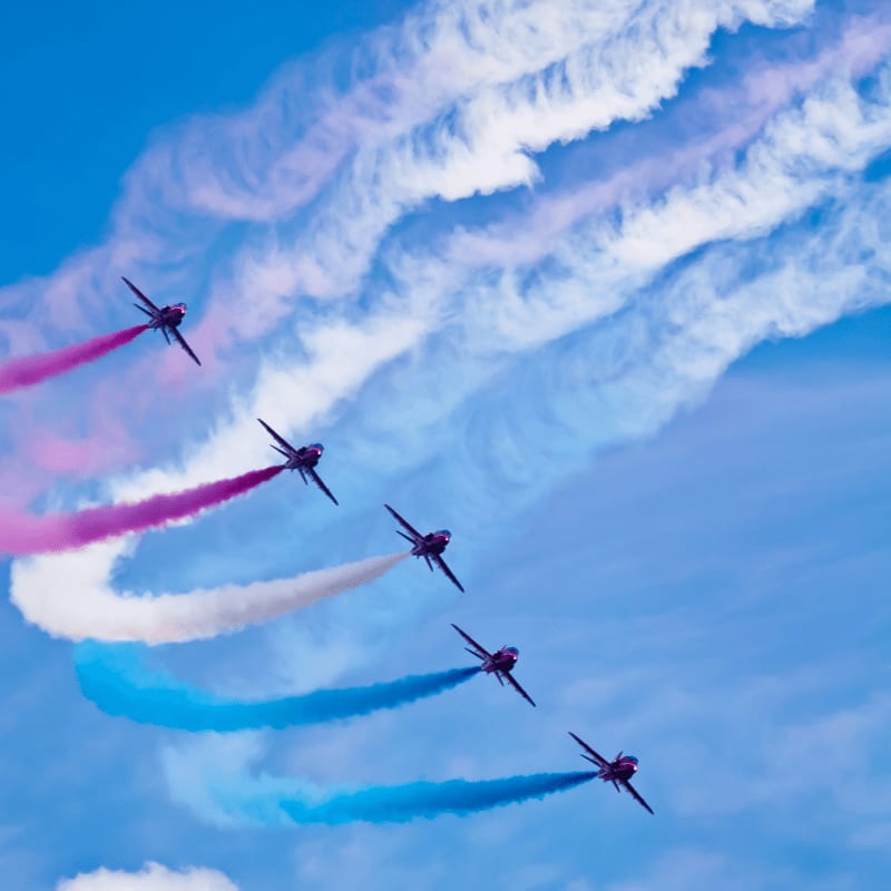 a group of airplanes flying through a blue sky