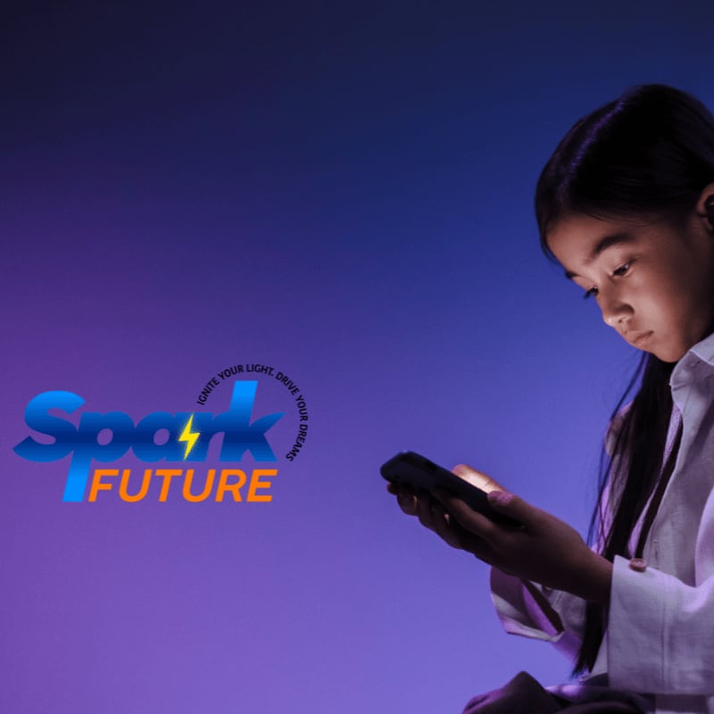 A young girl looks at her phone in the foreground, while the background features a vibrant purple and blue gradient with the text "Spark Future" and a lightning bolt.